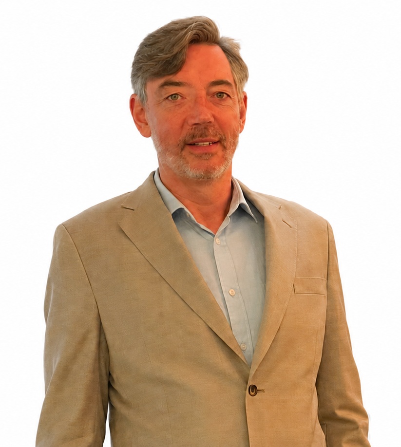 Professional portrait of Hugh Gunn, engineer, business owner, and author of The Leaderment Codex. He is looking toward the camera with a friendly smile, featuring short greying hair, a neatly trimmed beard, and wearing a tan blazer over a light blue button-down shirt. The background is transparent.